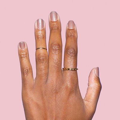 tan open hand with gold rings and shimmering beige nail polish